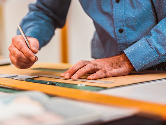 man drawing with ruler