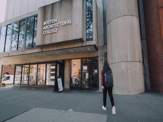 Student walking to the entrance of the BAC 320 Newbury building